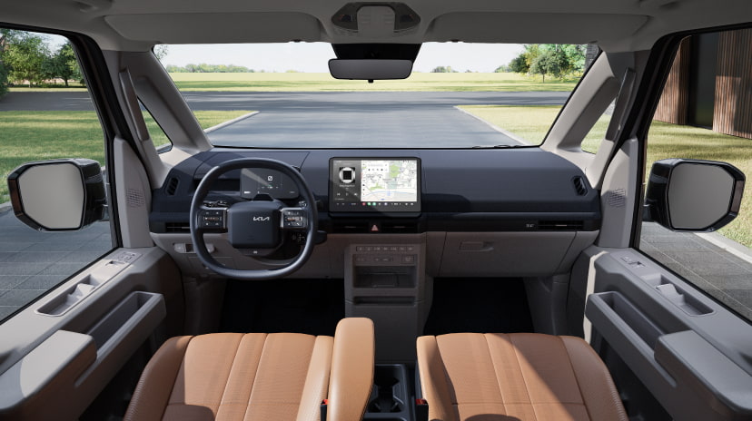 Vordere Innenansicht des Kia PV5 Passenger mit Panorama-Windschutzscheibe und Armaturenbrett